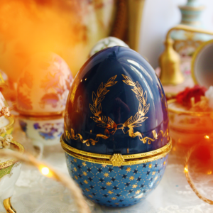 Le Couronnement, bougie œuf en porcelaine bleu et or parfumée au Monoï & Pêche