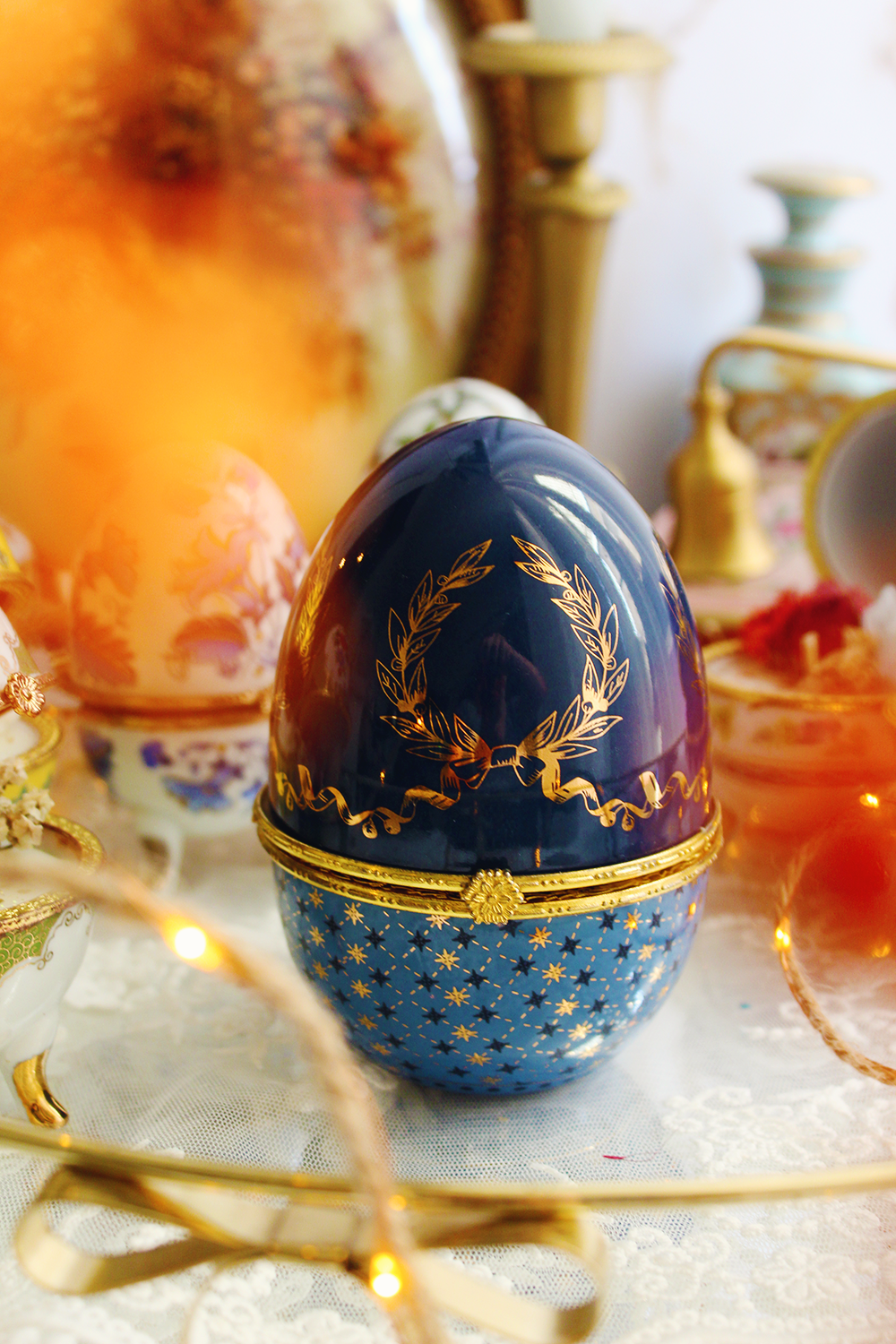 Le Couronnement, bougie œuf en porcelaine bleu et or parfumée au Monoï & Pêche