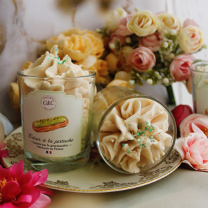 Deux bougies gourmandes Éclair à la pistache de Crèmes et Chantilly, l’une couchée et l’autre debout, avec leur décor de cire façon chantilly.